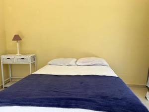 a bedroom with a bed with a blue blanket on it at Pousada in Guarujá