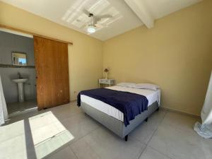 a bedroom with a bed and a bathroom with a sink at Pousada in Guarujá