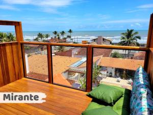 a balcony with a couch and a view of the ocean at Hostel Praia Centro Itanhaém in Itanhaém