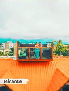 two people standing on the deck of a building at Hostel Praia Centro Itanhaém in Itanhaém