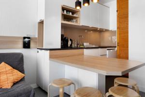 a kitchen with a counter and stools in a room at Studio Moderne Pied Des Pistes 4 p in La Pierre Saint Martin