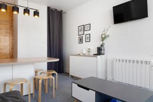 a living room with a table and two stools at Studio Moderne Pied Des Pistes 4 p in La Pierre Saint Martin