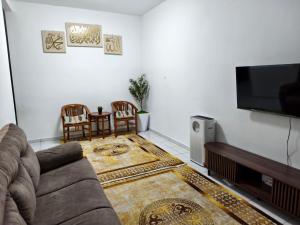 a living room with a couch and a flat screen tv at TheRapy House in Malacca