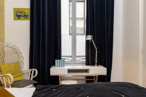 a bedroom with a bed and a desk with a window at Chambre De Charme Aux Chartrons in Bordeaux