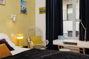 a bedroom with a bed and a desk and a window at Chambre De Charme Aux Chartrons in Bordeaux