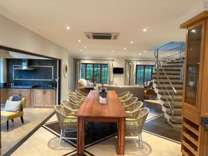 a kitchen and living room with a wooden table and chairs at Acacia House in Winterton