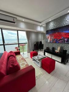 a living room with a red couch and red chairs at Tropical Executive Vista Pôr do Sol in Manaus