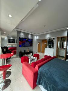 a living room with a large bed and red furniture at Tropical Executive Vista Pôr do Sol in Manaus