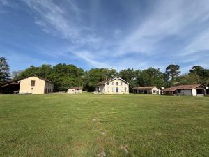a large field with houses in the background at Domaine de Quintessence in Saint-Justin