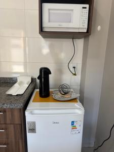 a microwave on top of a refrigerator in a kitchen at Amazon loft 03 in Sorriso +14 photos