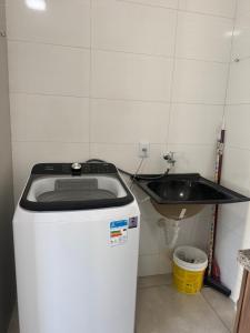 a bathroom with a sink and a washing machine at Amazon loft 03 in Sorriso
