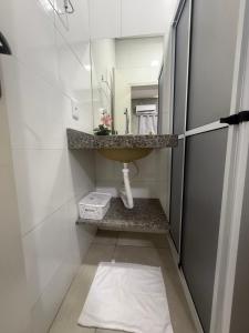a small bathroom with a sink and a mirror at Amazon loft 03 in Sorriso