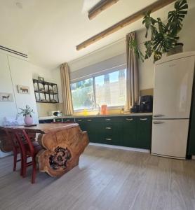 a kitchen with a wooden table and a refrigerator at מרום הגילבוע in Gid‘ona