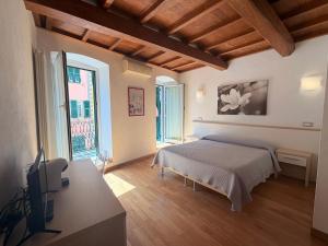 a bedroom with a bed and a desk with a television at La Dolce Vita in Riomaggiore