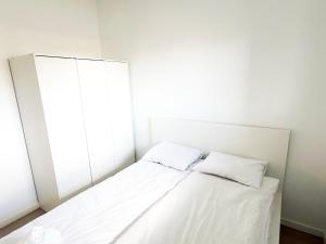 two beds in a room with white walls at Apartament Gozo in Łódź