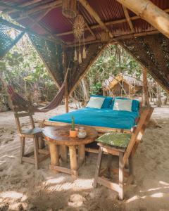 a bed and a table and a chair in a tent at Lote 10 Tayrona Glamping in Guachaca