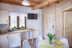 a kitchen with a table and chairs in a room at Leśne Siedlisko in Józefów