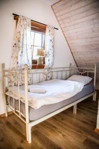 a white bed in a room with a window at Leśne Siedlisko in Józefów