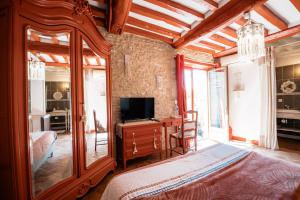 a bedroom with a bed and a tv in a room at Le chant des oiseaux in Ryes