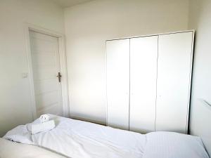 a bedroom with a large white bed and a large mirror at Apartament Gozo in Łódź