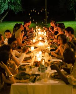 a group of people sitting at a long table with candles at Bohemian lodge guest house in Aït Namous +106 photos