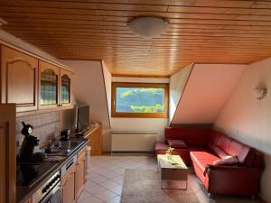 a living room with a red couch in a kitchen at Gästehaus Ritz in Wintrich