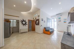 a living room with an orange couch and a kitchen at Piazza Pia Suites in Anzio +3 photos