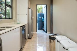 a kitchen with a door leading to a water tank at The Pearl Ballito in Ballito +14 photos
