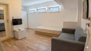 a small living room with a couch and a television at Alicante Otel - Adult Only in Bozcaada +59 photos