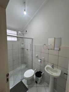 a bathroom with a toilet and a sink at Hotel Avenida ao lado do shopping in Guaratinguetá