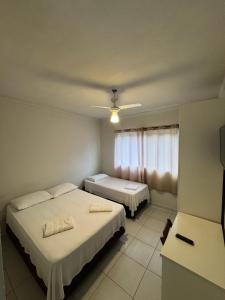 a hotel room with two beds and a window at Hotel Avenida ao lado do shopping in Guaratinguetá