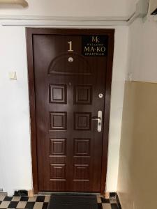 a brown door with a sign on it at Welcome Ma-Ko in Makó