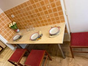 a wooden table with plates and glasses on it at Welcome Ma-Ko in Makó