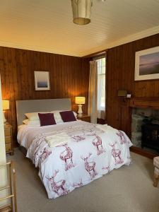 a bedroom with a bed and a fireplace at Westward Bed and Breakfast in Cannich