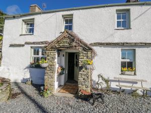 a dog standing in front of a white house at High Ickenthwaite Farmhouse in Ulverston