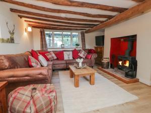 a living room with a couch and a fireplace at High Ickenthwaite Farmhouse in Ulverston