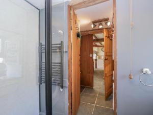 a glass shower in a room with a hallway at High Ickenthwaite Farmhouse in Ulverston +49 photos