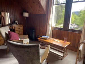 a living room with a table and chairs and a window at Westward Bed and Breakfast in Cannich