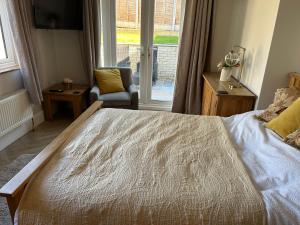 a bedroom with a bed and a chair and a window at Sunny Garden WFH Retreat with Private Entrance and Parking near NEC BHX JLR in Solihull