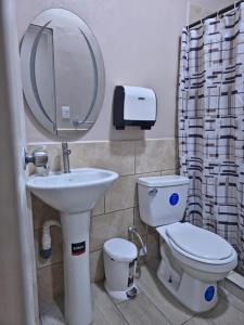 a bathroom with a sink and a toilet and a mirror at Rivera Solea in Llano de Los Patos +15 photos