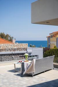 a patio with a bench and a table and the ocean at Ixia Pool Villa with sea view roof top in Ixia