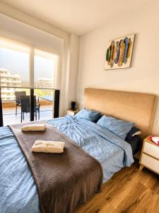 a bedroom with a bed with two towels on it at Claudia Luxury Apartment near the beach with a pool, gym, and secure gated parking in Arenales del Sol +39 photos