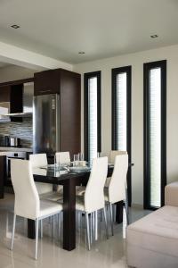 a dining room with a table and white chairs at Ixia Pool Villa with sea view roof top in Ixia