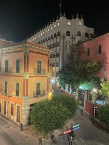 a city street at night with a large building at Casa del Agua in Guanajuato +19 photos