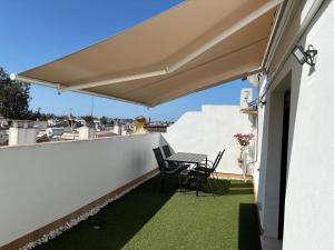 a patio with a table and chairs on a balcony at Ático luminoso con terraza privada in Sanlúcar de Barrameda