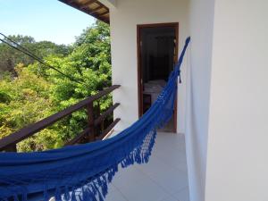 a hammock on the balcony of a house at Recanto Natureza in Imbassai