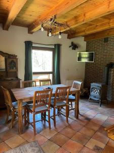 a dining room with a wooden table and chairs at Domek Leśny Anioł in Jarnołtówek +17 photos