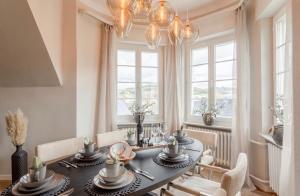a dining room with a table and chairs and windows at Villa Vulkaneifel in Kelberg
