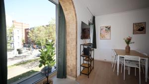 a living room with a table and a large window at Anvers Apartment in Antwerp