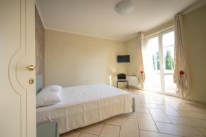 a bedroom with a bed and a large window at Villa La Corte in Cesa